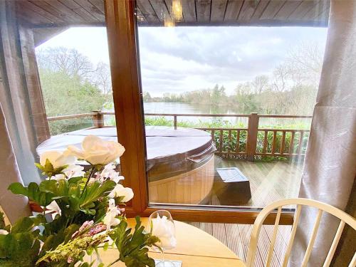 a room with a balcony with a view of the water at Holly Lodge 14 Hot Tub in York