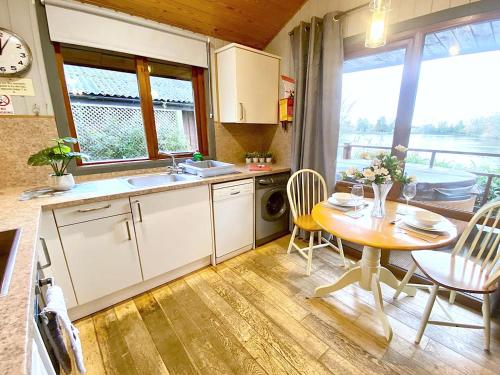 a kitchen with a table and a sink and a table and chairs at Holly Lodge 14 Hot Tub in York