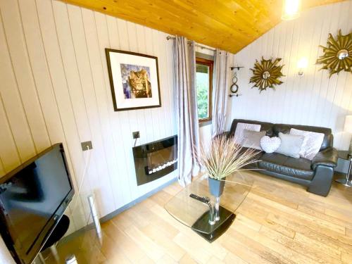 a living room with a couch and a television at Holly Lodge 14 Hot Tub in York