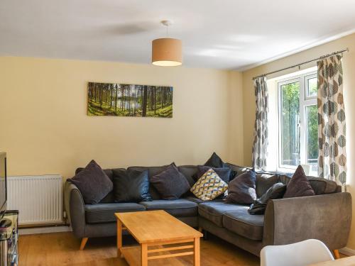 a living room with a couch and a table at Honey Lodge in Gunnislake