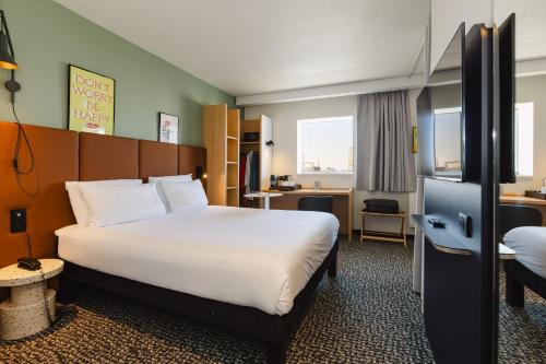 a hotel room with a bed and a desk at Hotel ibis Rennes Centre Gare Sud in Rennes