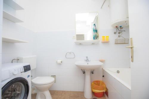 bagno bianco con lavatrice e lavandino di Feel the sea a Primošten
