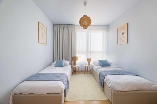 グダニスクにあるElite Apartments Beachside Luxury with Balconyの窓のある部屋に並んだベッド