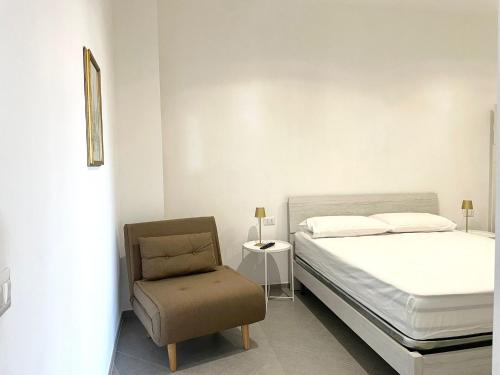 a bedroom with a bed and a chair at Palazzo Galante in Ginosa Marina