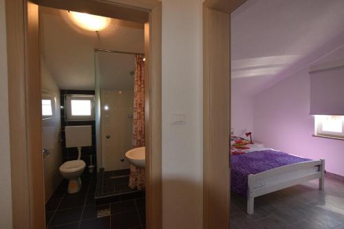 łazienka z łóżkiem, toaletą i umywalką w obiekcie Apartments Batarilo w Biogradzie na Moru