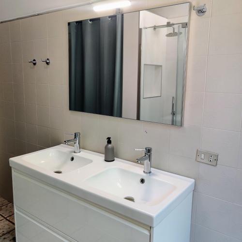 a bathroom with a white sink and a mirror at Peaceful Lakefront in Marone