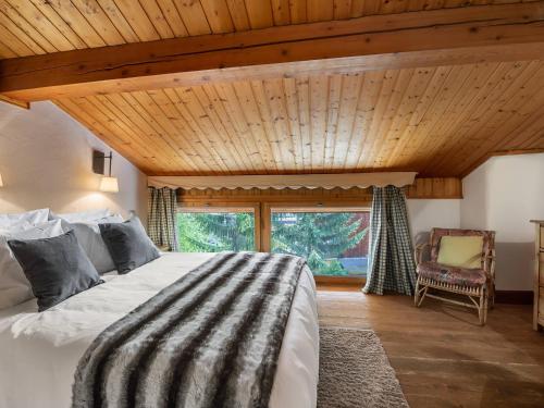 - une chambre avec un grand lit et un plafond en bois dans l'établissement Chalet familial au centre de Courchevel Le Praz, proche pistes et commerces, terrasse plein sud - FR-1-568-10, à Courchevel