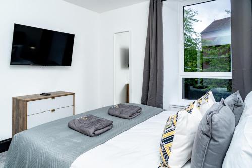a bedroom with a bed and a tv and a window at King Bed - Sleeps 2 - Wi-Fi - Good Amenities Around Area - Smart TV's in All Rooms - Secure Entry - Get in touch Central Short Lets Dundee in Dundee