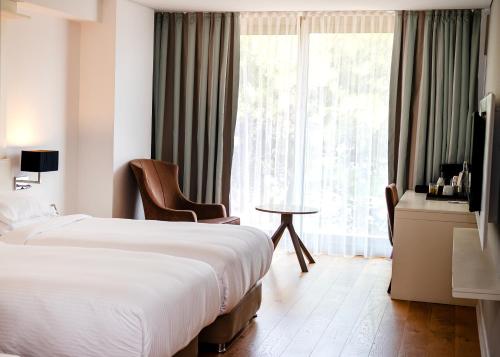 a hotel room with two beds and a window at Rixos Premium Dubrovnik in Dubrovnik