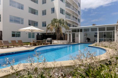 een zwembad voor een gebouw bij Sunny Courtyard Dreaming Downtown with Pool & Gym in Mount Maunganui