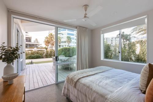 een slaapkamer met een bed en een groot raam bij Sunny Courtyard Dreaming Downtown with Pool & Gym in Mount Maunganui