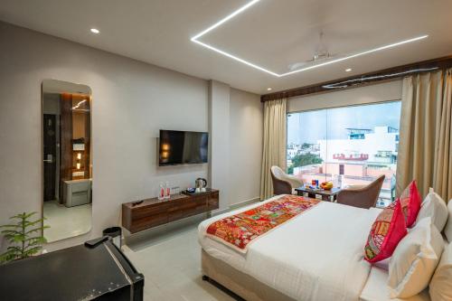 a hotel room with a bed and a television at Tripli Hotels Evara Inn in Varanasi