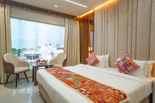 a hotel room with a large bed and a window at Tripli Hotels Evara Inn in Varanasi