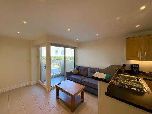 a kitchen and a living room with a couch at West Beach - Holiday Apartments in Westward Ho