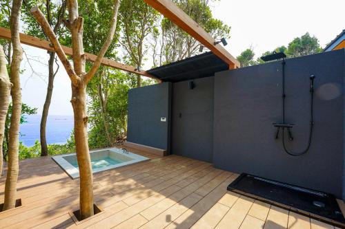 a bathroom with a shower and a tree at UMIBE Terrace in Shima