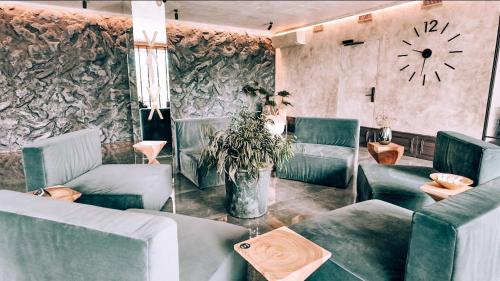 a living room with couches and a clock on the wall at VAIVA Apartments, Palanga in Šventoji