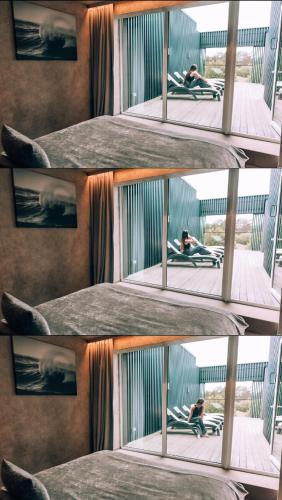 a person sitting on a bed in a prison cell at VAIVA Apartments, Palanga in Šventoji
