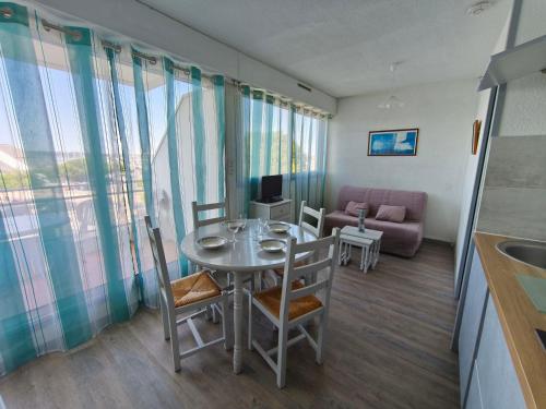 un salon avec une table, des chaises et un canapé dans l'établissement Studio cosy à La Rochelle avec balcon et parking privé - FR-1-551-52, à La Rochelle