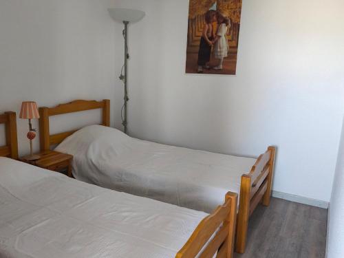 deux lits dans une chambre avec un tableau au mur dans l'établissement Studio cosy à La Rochelle avec balcon et parking privé - FR-1-551-52, à La Rochelle