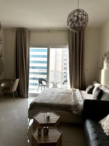 a bedroom with a bed and a couch and a large window at Canal View Studio in AG Tower in Sabkhah