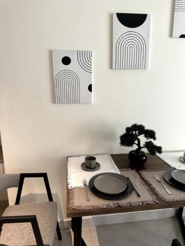 a table with two plates and a tree on it at Canal View Studio in AG Tower in Sabkhah