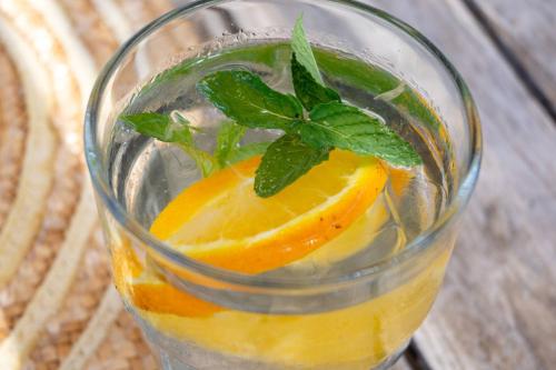 a glass of orange juice with a mint leaf on top at Masseria Borgo Sentinella in Torre dell'Orso