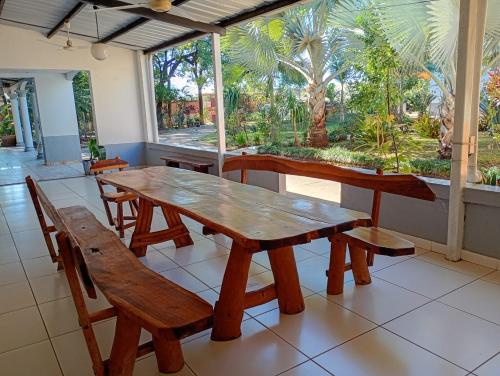 Una mesa y sillas de madera en una habitación con ventana. en CEDE Inn Hotel, en Encarnación
