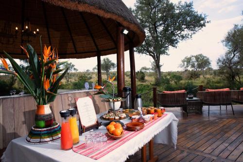 Mluwati Concession にあるHoyo Hoyo Safari Lodgeのデッキにテーブルと飲食