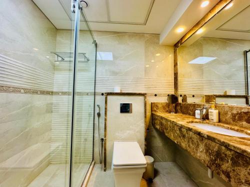 ein Badezimmer mit Dusche, Toilette und Waschbecken in der Unterkunft Magic waves holiday in Dubai