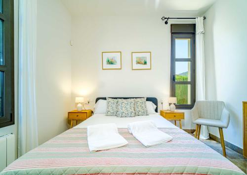Un dormitorio con una cama con dos almohadas y una silla. en Villa Abaesko by Rock Rentals, en Jávea