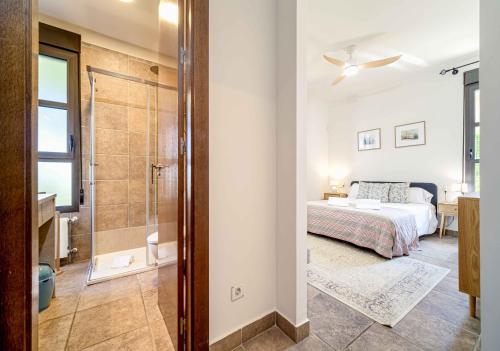 Un dormitorio con una cama y una ducha a ras de suelo. en Villa Abaesko by Rock Rentals, en Jávea