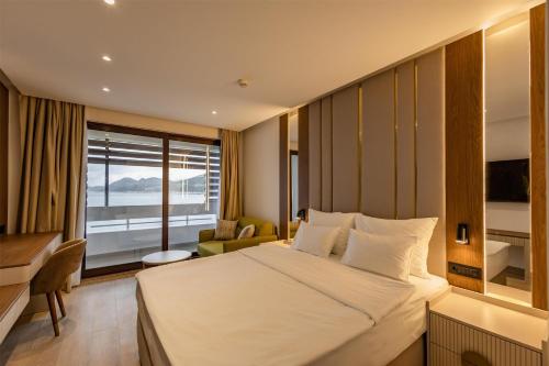 a hotel room with a large bed and a desk at Radisson Resort Ruza Vjetrova in Dobra Voda