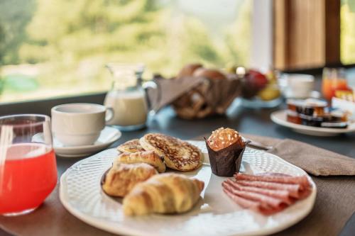 a table with a plate of pastries and other foods at HOTEL AURONZO - outdoor basecamp in Auronzo di Cadore