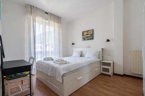 a white bedroom with a bed and a window at Elegant Apartments Rapallo in Rapallo