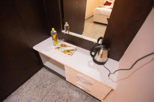 a bathroom counter with a mirror and a sink at Hotel Mysuru Haven in Mysore