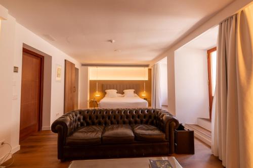 a living room with a couch and a bed at Mirador de Dalt Vila-Relais & Chateaux in Ibiza Town