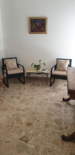 a living room with two chairs and a table at Lyberty in Randazzo