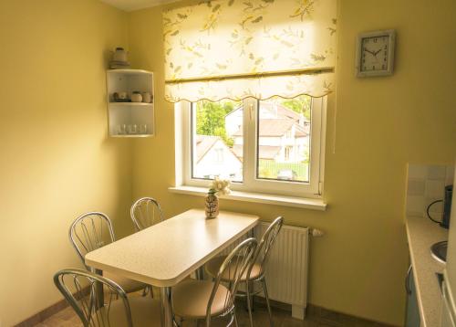 a table and chairs in a kitchen with a window at Viktoras Apartments in Palanga