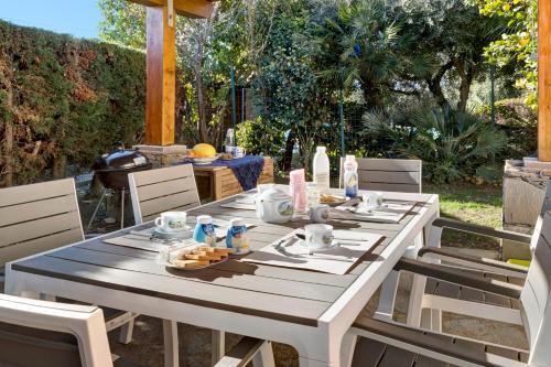 - une table blanche avec de la nourriture sur la terrasse dans l'établissement Home Charlene, à Albenga