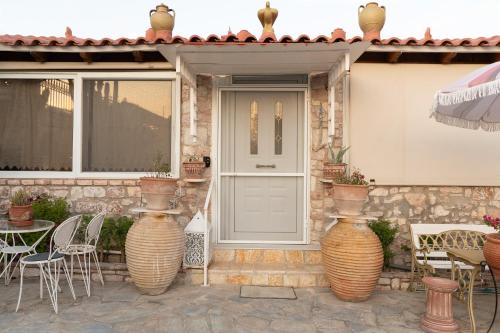 a house with two large vases in front of a door at The Stone Nest in Koroni