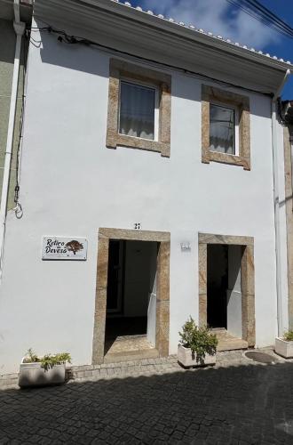 a white building with two doors and some plants at Retiro da Devesa in Pedrógão Grande