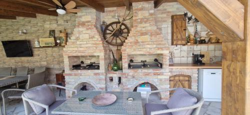 a kitchen with a table and a brick wall at Kapitány MP Art Luxury Apartman in Balatonboglár
