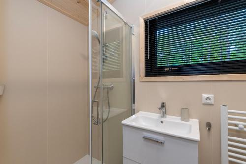 a bathroom with a sink and a shower at Tiny House de Hazelaar in Zuidwolde