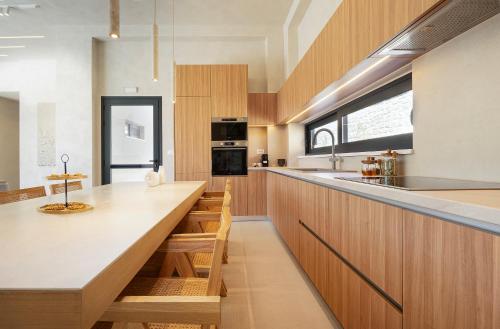 a kitchen with wooden cabinets and a large counter top at Elithos Villa in Vryses