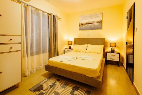 a bedroom with a bed and a large window at Villa Blanche in Douala