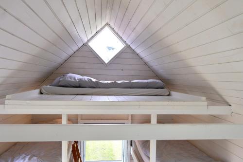a bed in a tiny house with a window at Aalborg Hytteø in Aalborg
