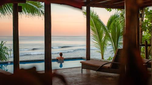 a woman in a swimming pool looking out at the ocean at Savasi Island Resort in Savusavu