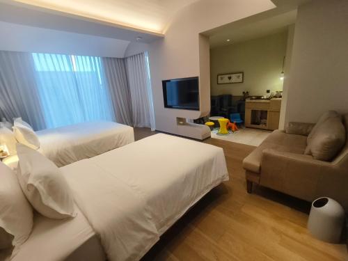 a hotel room with two beds and a couch at Guanlu Art Hotel in Huadu