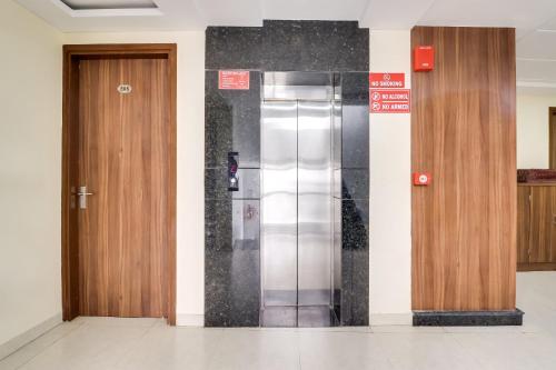 a elevator in a building with two wooden doors at Super Capital O Seven Wonders Inn Near Sahara Ganj Mall in Lucknow