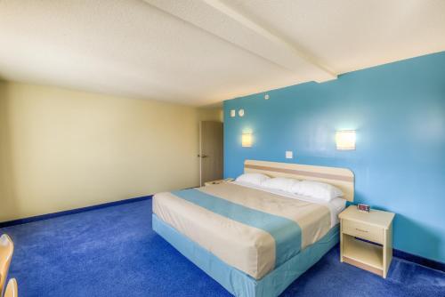 a bedroom with a bed in a blue room at Aurora Inn Estevan in Estevan